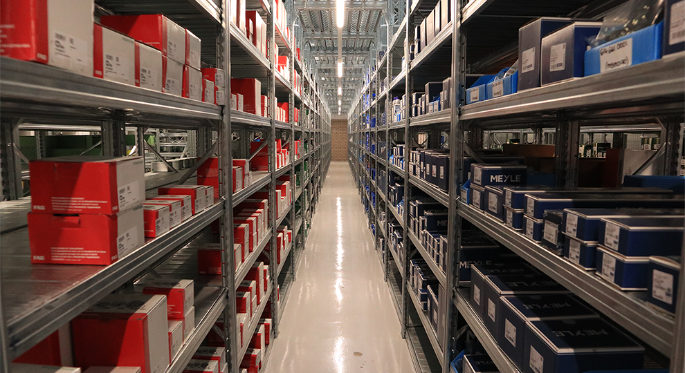 Shelving filled with car parts in red, blue and white boxes.